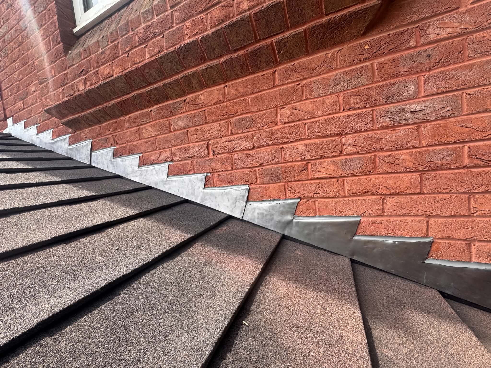 New stepped lead flashing dressed into brickwork above a tiled roof